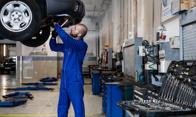 A Man in Blue Suit Checking a Car A Man in Blue Suit Checking a Car