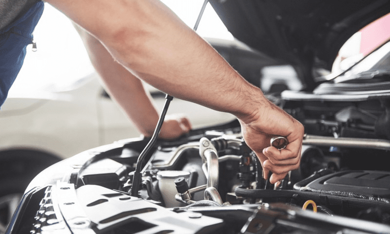 New Project (35) Close up hands of an unrecognizable mechanic doing car service and maintenance.